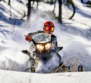 Riding a snowmobile through the forest. 