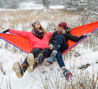 Family sitting on a hammock in the snow. 