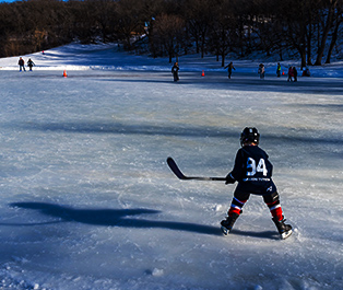 Kids playing ice hockey on a frozen lake. 